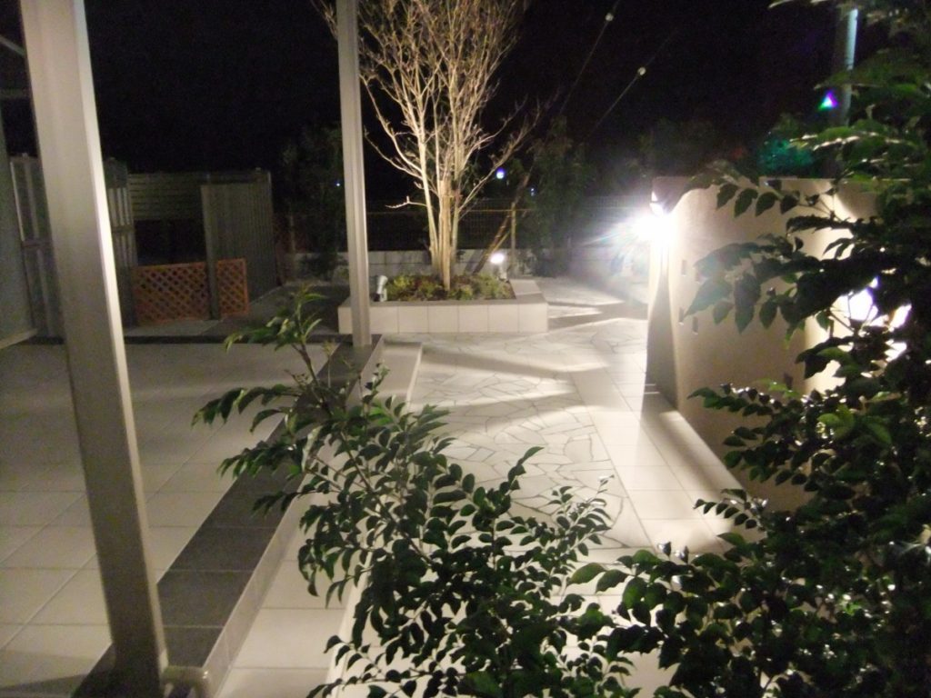 クラシックなライトに映える石張りの庭