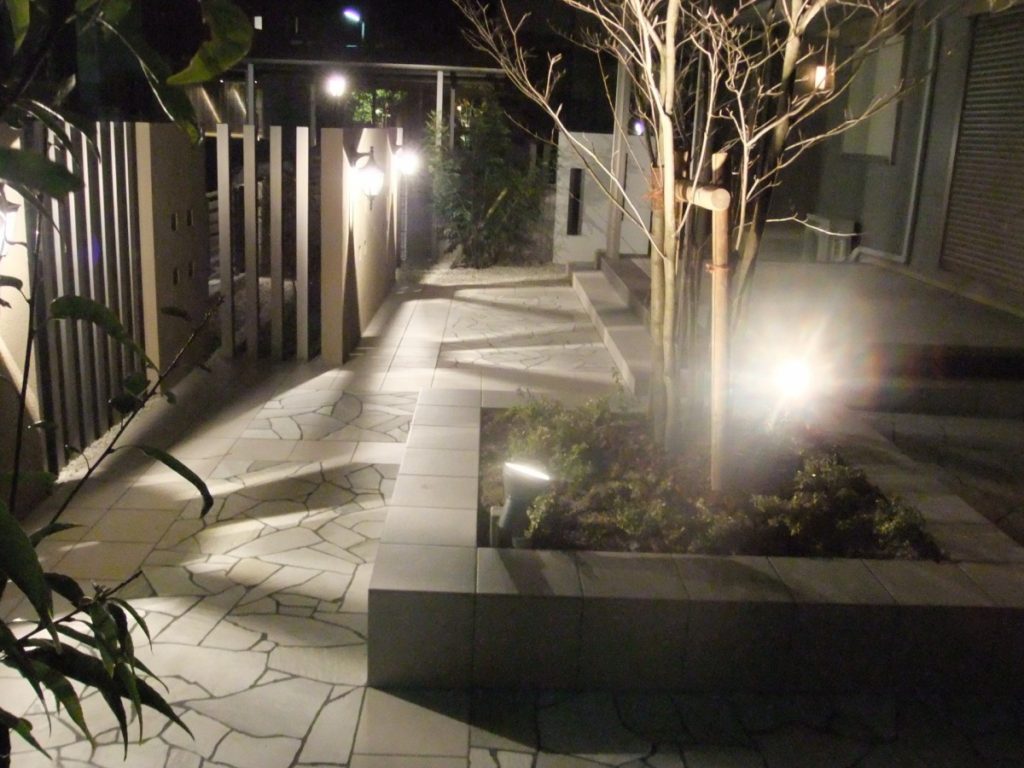 クラシックなライトに映える石張りの庭