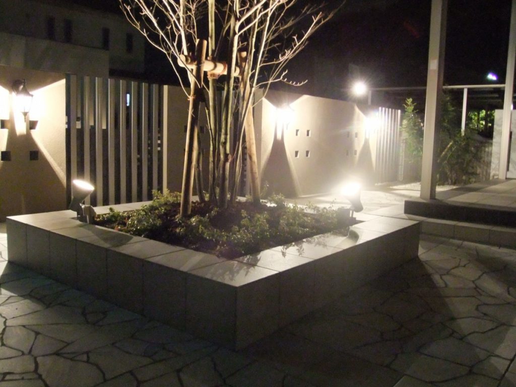 クラシックなライトに映える石張りの庭